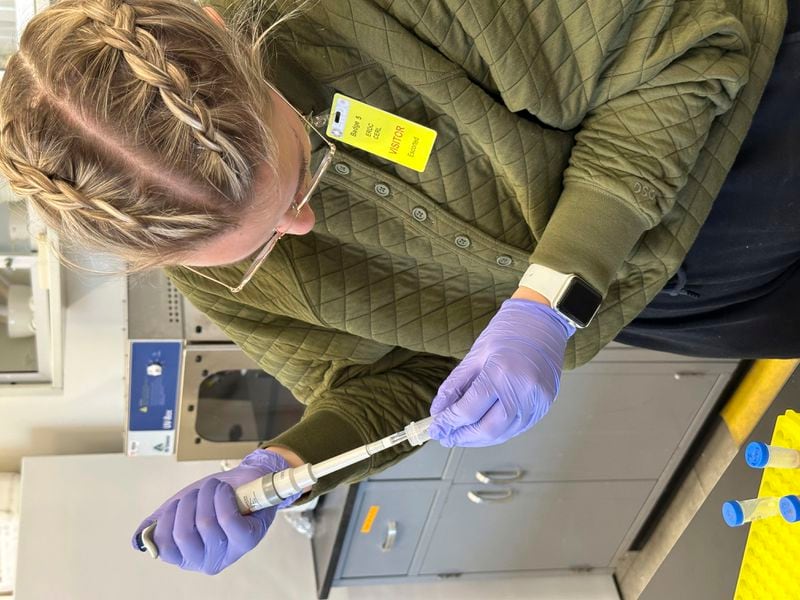 This photo provided by Steve Travers shows Trinity Atkins extracting DNA from a sample of a western prairie fringed orchid on Wednesday, March 6, 2024, at the U.S. Army Construction Engineering Research Laboratory in Champaign, Ill. (Steve Travers via AP)