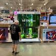 A shopper examines large-screen televisions on display in a Costco warehouse Thursday, Sept. 19, 2024, in Lone Tree, Colo. (AP Photo/David Zalubowski)