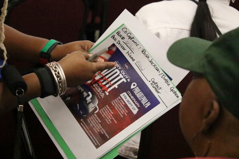 An organizer with the National Action Network signs people in ahead of a Get Out the Vote bus tour toward Philadelphia in the Harlem neighborhood of New York on Friday, Sep. 27, 2024. (AP Photo/Noreen Nasir)