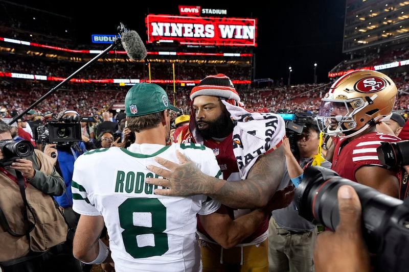 New York Jets quarterback Aaron Rodgers (8) talks with San Francisco 49ers offensive tackle Trent Williams, center right, after an NFL football game in Santa Clara, Calif., Monday, Sept. 9, 2024. (AP Photo/Godofredo A. Vásquez)