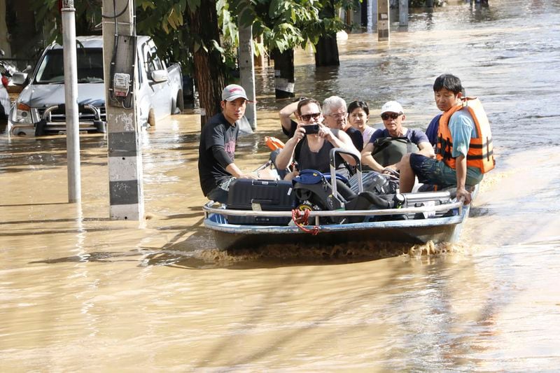 Tourists evacuate from a flood-hit area in Chiang Mai Province, Thailand, Saturday, Oct. 5, 2024. (AP Photo/Wichai Tapriew)