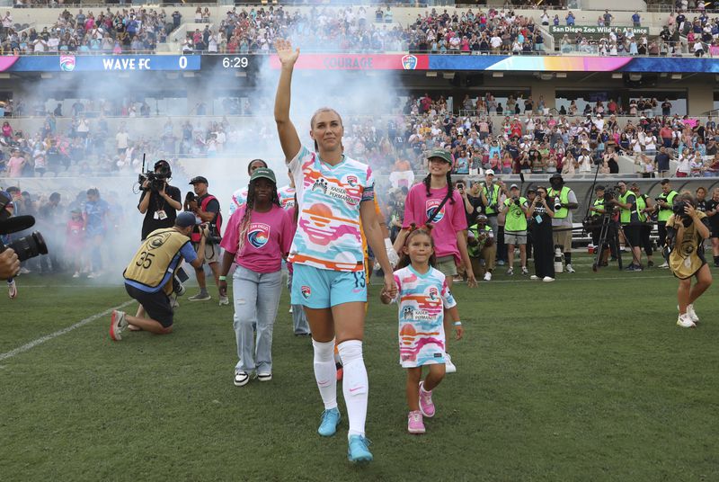 San Diego Wave's Alex Morgan waves before the start of an NWSL soccer game against the North Carolina Courage on Sunday, Sept. 8 2024, in San Diego. (Sandy Huffaker/The San Diego Union-Tribune via AP)