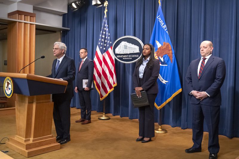 Attorney General Merrick Garland, left, speaks during a news conference at the Department of Justice, Tuesday, Sept. 24, 2024, in Washington. (AP Photo/Mark Schiefelbein)