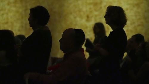 Worshipers stand to say the names of loved ones in need of prayers during a Shabbat service, Friday, Sept. 27, 2024, at Temple Beth Sholom in Miami Beach, Fla. (AP Photo/Wilfredo Lee)