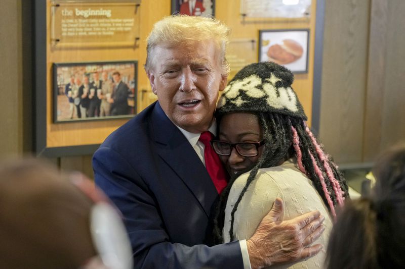 FILE - Republican presidential candidate former President Donald Trump, left, hugs Michaelah Montgomery, a local conservative activist, as he visits a Chick-fil-A eatery, Wednesday, April 10, 2024, in Atlanta. President Joe Biden and Trump are working to win over Georgia voters ahead of the pair's first 2024 debate scheduled for Thursday, June 27, 2024 in Atlanta. .(AP Photo/Jason Allen, File)