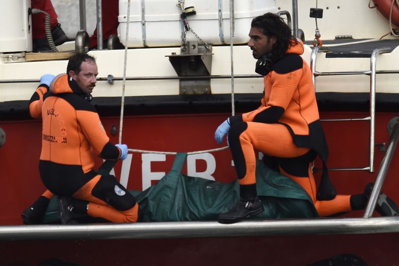 Italian Firefighters scuba divers bring ashore in a green bag the body of one of the victims of the UK flag vessel Bayesian, Wednesday, Aug. 21, 2024. The sail yacht was hit by a violent sudden storm and sunk early Monday, while at anchor off the Sicilian village of Porticello near Palermo, in southern Italy. (AP Photo/Salvatore Cavalli)