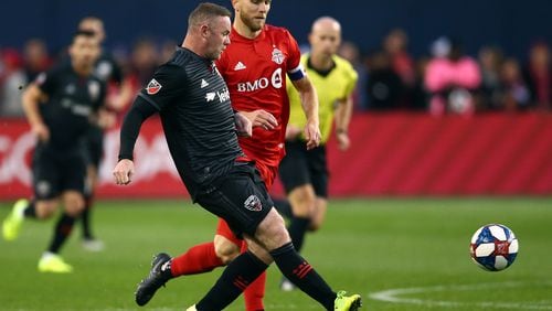 TORONTO, ON - OCTOBER 19:  Wayne Rooney #9 of D.C. United is tackled by Michael Bradley #4 of Toronto FC during an MLS First Round Playoff game at BMO Field on October 19, 2019 in Toronto, Canada.  (Photo by Vaughn Ridley/Getty Images)