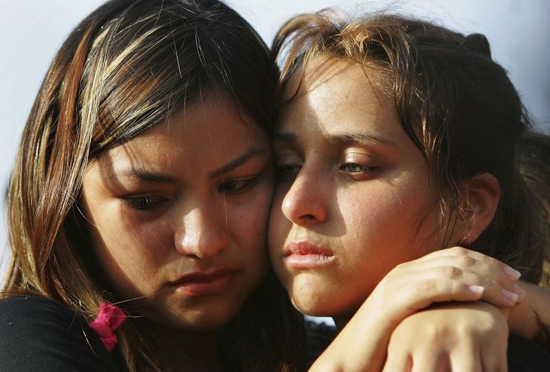 TEL AVIV, ISRAEL - JULY 13:  Schoolfriends of 16-year-old Israeli teenager girls Nofar Horvitz and Rachel Ben Abu comfort each other as they grieve over their adjoining graves during her funeral July 13, 2005 at Tel Aviv's Yarkon cemetery, Israel. The childhood friends were two of the four victims of a Palestinian suicide bombing in the Israeli town of Netanya the previous evening and were buried in adjacent graves in a joint funeral. (Photo by David Silverman/Getty Images)