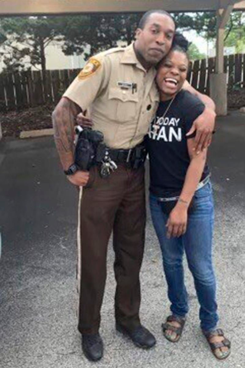 In this undated photo provided by Charlene Jefferson in August 2024, Travis Brown, when he was St. Louis County police officer, stands with Danielle Oliver. Brown, a Ferguson Police officer, suffered a severe brain injury after he was knocked to the ground Friday, Aug. 9, 2024, during a protest in Ferguson, Mo., on the 10th anniversary of the shooting death of Michael Brown. (Charlene Jefferson via AP)