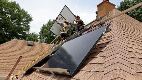 060722 Ellenwood: Alternative Energy Southeast employees Aaron Basto, center, and Russell McCune, right, installs eighteen solar panels to the roof of a resident Tuesday, June 7, 2022, in Ellenwood, Ga. (Jason Getz / Jason.Getz@ajc.com)