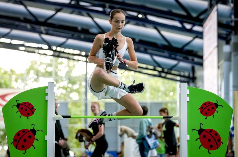 A girl clears the bar during the first German Hobby Horsing Championship in Frankfurt, Germany, Saturday, Sept. 14, 2024. (AP Photo/Michael Probst)