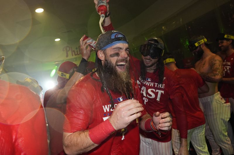 Philadelphia Phillies' Brandon Marsh, center left, and Matt Strahm celebrate after the Phillies won a baseball game against the Chicago Cubs to clinch the NL East title, Monday, Sept. 23, 2024, in Philadelphia. (AP Photo/Matt Slocum)