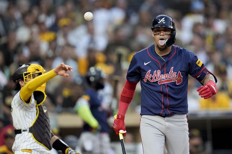 Atlanta Braves' Orlando Arcia reacts after dodging an inside pitch during the third inning in Game 1 of an NL Wild Card Series baseball game against the San Diego Padres, Tuesday, Oct. 1, 2024, in San Diego. (AP Photo/Gregory Bull)