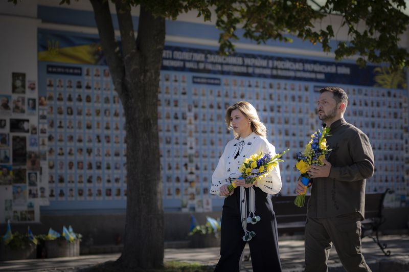 In this photo provided by the Ukrainian Presidential Press Office, Ukrainian President Volodymyr Zelenskyy and his wife Olena lay flowers at the Memorial Wall of Fallen Defenders of Ukraine in Russian-Ukrainian War during celebration of the Ukrainian Independence Day in Kyiv, Ukraine, Saturday, Aug. 24, 2024. (Ukrainian Presidential Press Office via AP)