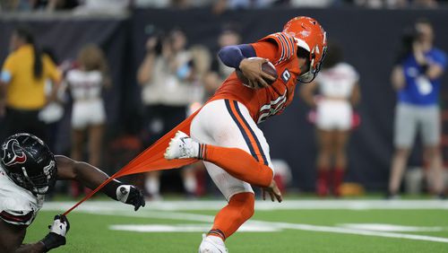 Chicago Bears quarterback Caleb Williams, right, scrambles away from Houston Texans defensive end Danielle Hunter during the second half of an NFL football game Sunday, Sept. 15, 2024, in Houston. (AP Photo/Eric Gay)