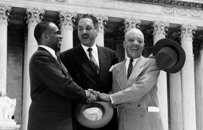 In this May 17, 1954, file photo, George E.C. Hayes, left, Thurgood Marshall, center, and James M. Nabrit join hands outside the U.S. Supreme Court in Washington, D.C., after justices declared in the Brown v. Board of Education decision that separate but equal schools for black children were unconstitutional.