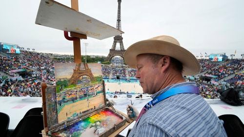 Peter Spens, of London, England, paints the scene at Eiffel Tower Stadium during a beach volleyball match at the 2024 Summer Olympics, Saturday, July 27, 2024, in Paris, France. (AP Photo/Robert F. Bukaty)