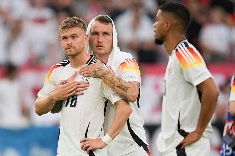 Germany's Maximilian Mittelstadt, left, and Germany's David Raum reacts at the end of a quarter final match between Germany and Spain at the Euro 2024 soccer tournament in Stuttgart, Germany, Friday, July 5, 2024. (AP Photo/Matthias Schrader)
