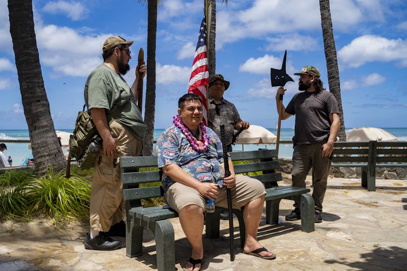 Members of Hawaii Firearms Coalition gather in Waikiki with their non-firearm weapons on Saturday, June 22, 2024, in Honolulu, Hawaii. (AP Photo/Mengshin Lin)