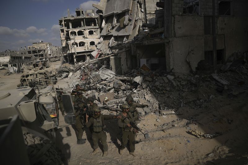 Israeli soldiers take up position next to destroyed buildings following Israeli strikes during a ground operation in the Gaza Strip on Friday, Sept. 13, 2024. (AP Photo/Leo Correa)