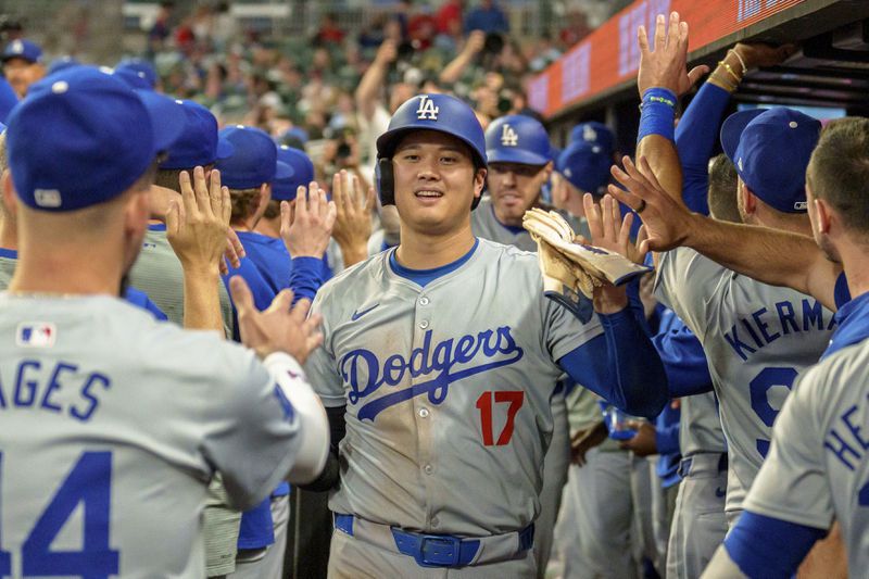 Los Angeles Dodgers' Shohei Ohtani (17) celebrates in the dugout after Freddie Freeman hit a three-run home run in the seventh inning of a baseball game against the Atlanta Braves, Monday, Sept. 16, 2024, in Atlanta. (AP Photo/Jason Allen)