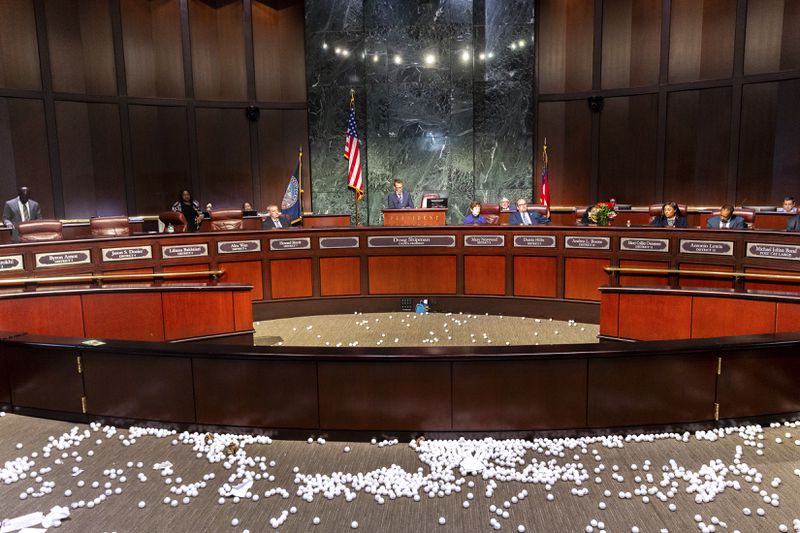 Ping pong balls litter the floor after opponents of the under-construction law enforcement training center known to some as Cop City disrupted the City Council meeting at City Hall in Atlanta on Monday, Sept. 16, 2024. (Arvin Temkar/Atlanta Journal-Constitution via AP)