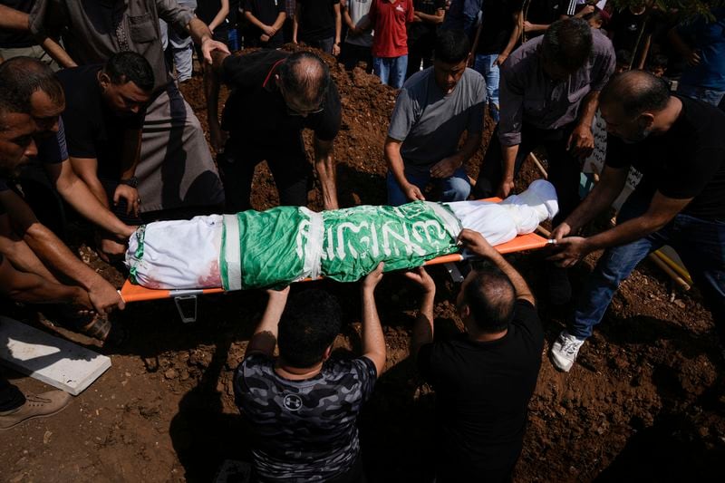 Mourners carry the body of Loujain Muslah, 16, wrapped with Hamas flag during her funeral in the West Bank village of Kafr Dan near Jenin, Wednesday, Sept. 4, 2024. The Palestinian Health Ministry said a 16 year old Palestinian girl was shot dead Tuesday by Israeli fire in the northern West Bank village of Kufr Dan. The Israeli army did not respond to a request for comment about the shooting, which comes during a weeklong Israeli army operation in the north of the territory. (AP Photo/Majdi Mohammed)