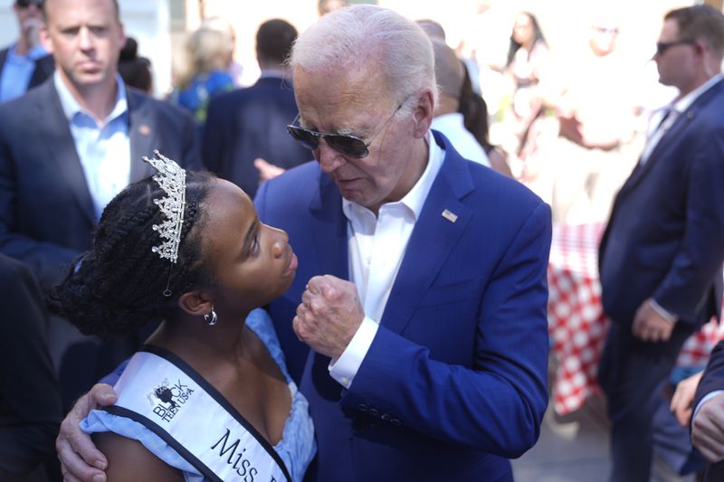 President Joe Biden, right, greets a young supporter at a campaign rally in Harrisburg, Pa., on Sunday, July 7, 2024. (AP Photo/Manuel Balce Ceneta)