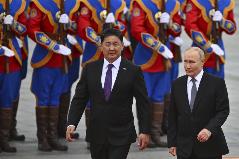 Russian President Vladimir Putin, right, walks with Mongolian President Ukhnaagiin Khurelsukh, left, during a welcoming ceremony at Sukhbaatar Square in Ulaanbaatar, Mongolia, Tuesday, Sept. 3, 2024. (Kristina Kormilitsyna, Sputnik, Kremlin Pool Photo via AP)