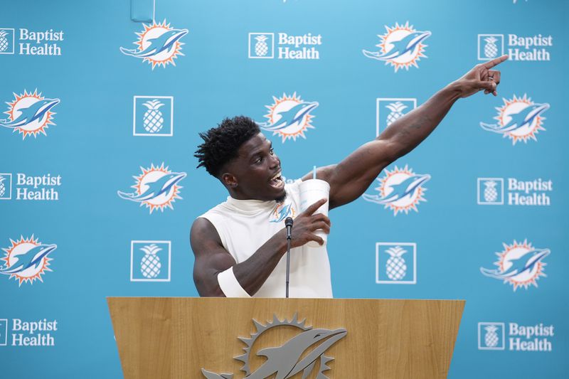 Miami Dolphins wide receiver Tyreek Hill (10) gestures as he calls for the police officer involved in his traffic stop to be fired, during a press conference following a team practice, Wednesday, Sept. 11, 2024, in Miami Gardens, Fla. (AP Photo/Rebecca Blackwell)