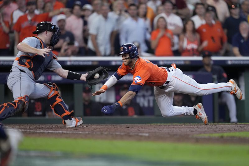 Detroit Tigers catcher Jake Rogers reaches out for the throw to the plate as Houston Astros' Jeremy Pena, right, scores on a Jose Altuve sacrifice fly in the seventh inning of Game 2 of an AL Wild Card Series baseball game Wednesday, Oct. 2, 2024, in Houston. (AP Photo/Kevin M. Cox)