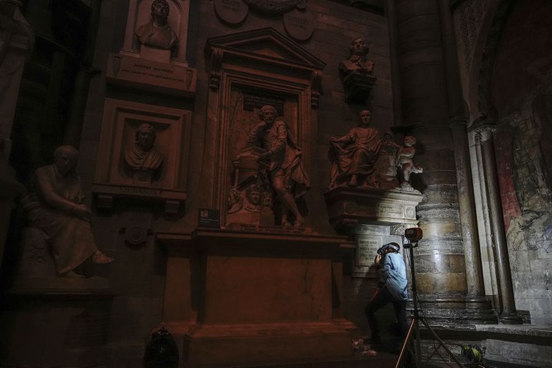 Conservator Lucy Ackland adds the finishing touches to the memorial to Charlotte, Emily and Anne Bronte at Poets' Corner in Westminster Abbey in London, England, Thursday Sept. 26, 2024. (Aaron Chown/PA via AP)