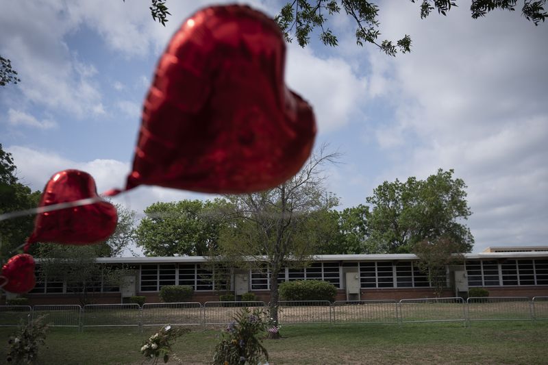 FILE - A heart-shaped balloon flies decorating a memorial site outside Robb Elementary School in Uvalde, Texas, Monday, May 30, 2022. The 19 fourth-graders and two teachers killed at the elementary school are being remembered, Friday, May 24, 2024 as the second anniversary of the one of the deadliest school shootings in U.S. history is marked. (AP Photo/Wong Maye-E, File)