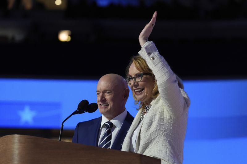 Former Rep. Gabrielle Giffords, of Arizona, right, and her husband Sen. Mark Kelly, D-Ariz., appear during the Democratic National Convention Thursday, Aug. 22, 2024, in Chicago. (AP Photo/Paul Sancya)