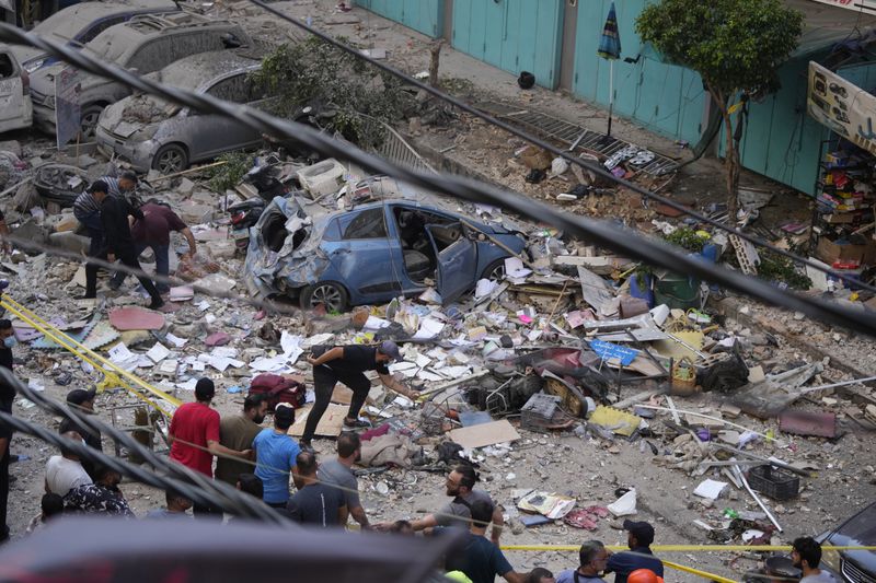 Residents check the site of an Israeli airstrike in Beirut's southern suburbs, Tuesday, Sept. 24, 2024. (AP Photo/Hassan Ammar)