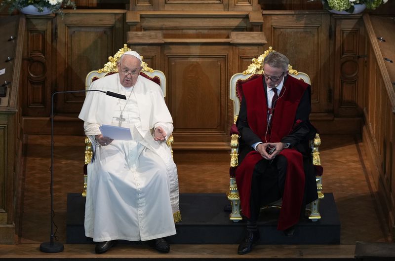 Pope Francis, left, flanked by Rector Luc Sels, delivers his speech during his meeting with the professors in the Promotiezaal of the Catholic University of Leuven, Belgium, Friday, Sept. 27, 2024. (AP Photo/Andrew Medichini)