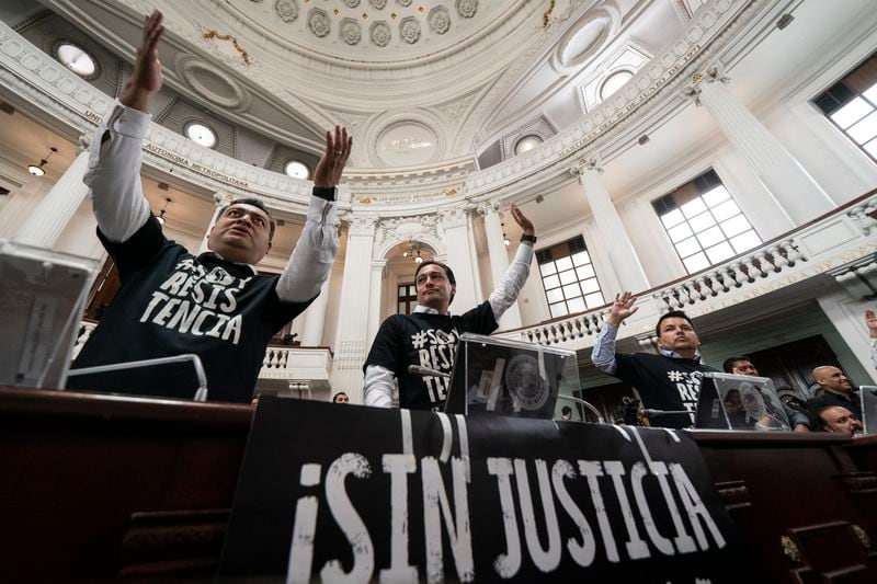 Mexico City lawmakers demonstrate against judicial reform, by signs that reads in Spanish "No justice" at the city Congress in Mexico City, Thursday, Sept. 12, 2024. (AP Photo/Felix Marquez)