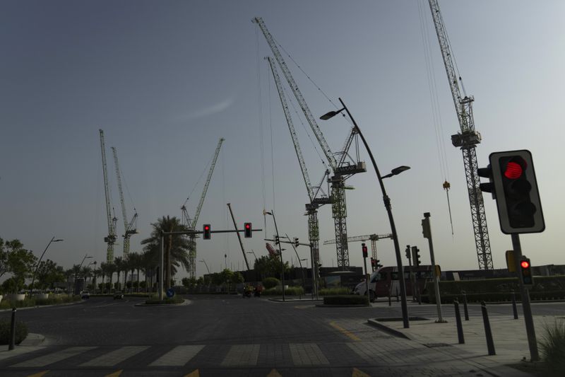 Cranes loom over a construction site, towering above the road in Dubai, United Arab Emirates, on Tuesday, August 13, 2024. (AP Photo/Altaf Qadri)